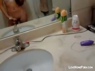 Monada joven asiática masturbándose en la baño