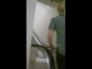 Sexig röv på en escalator i yoga byxor