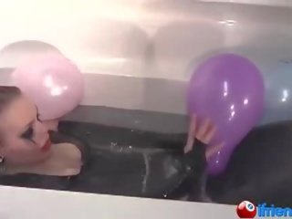 胶乳 连衣裙的 女孩 同 气球 在 一 浴缸
